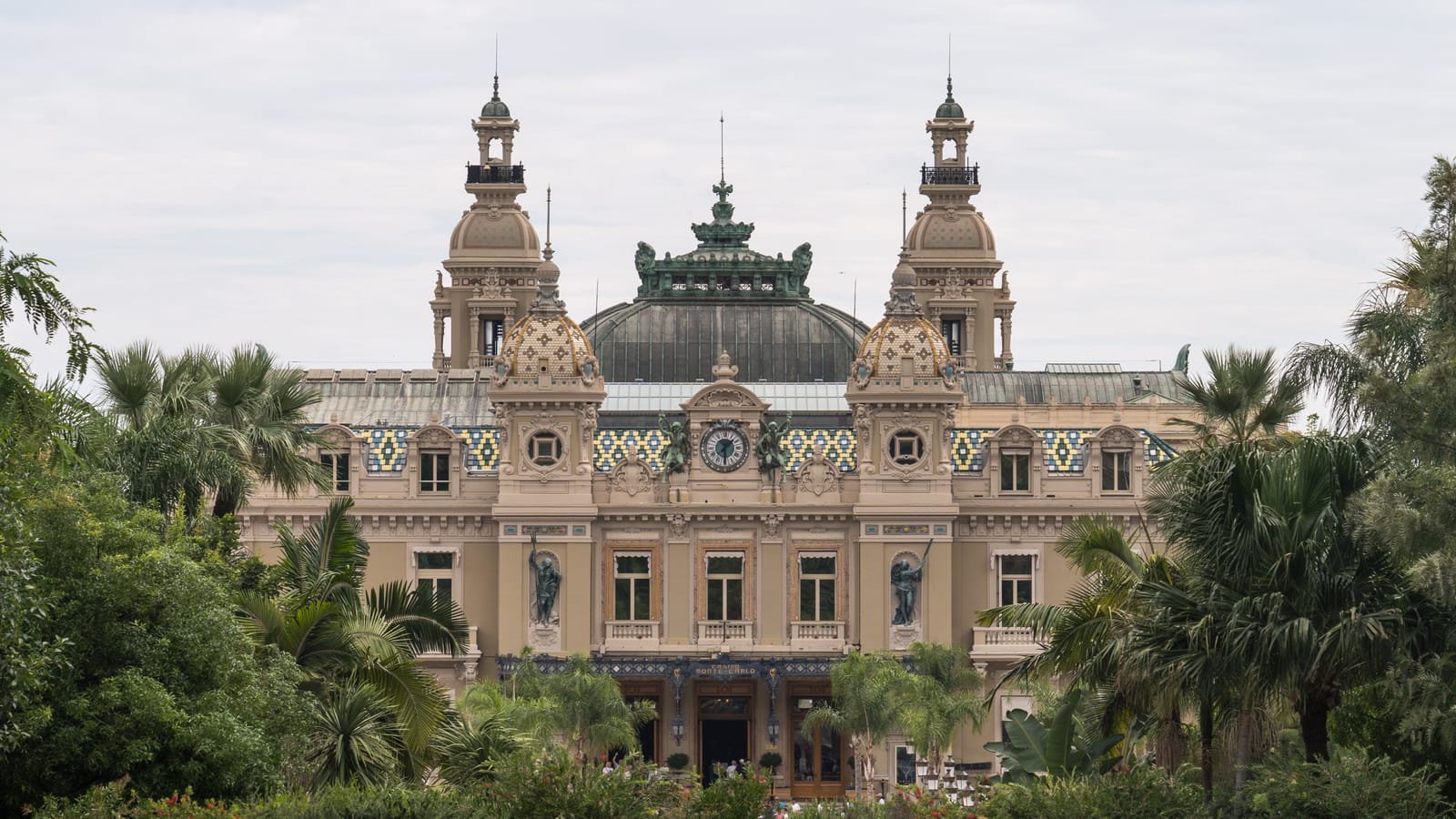 The main facade of the Casino de Monte-Carlo with its clock and twin towers, seen across the gardens