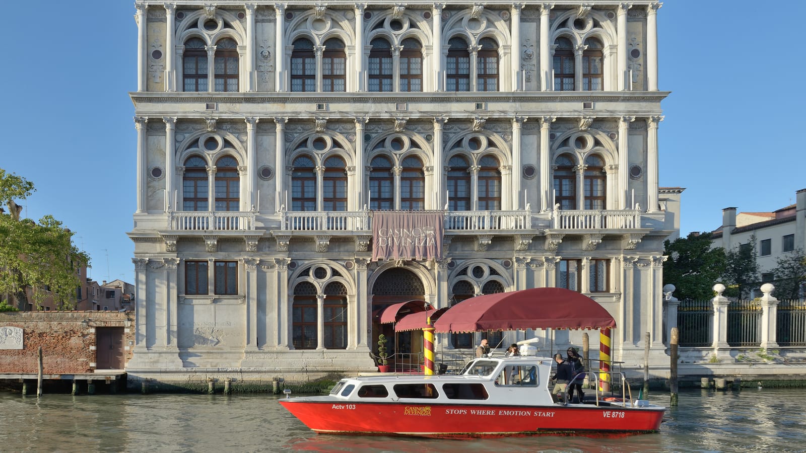 The Grand Canal facade of Ca’ Vendramin Calergi, home of the Casino di Venezia, with a casino boat in front